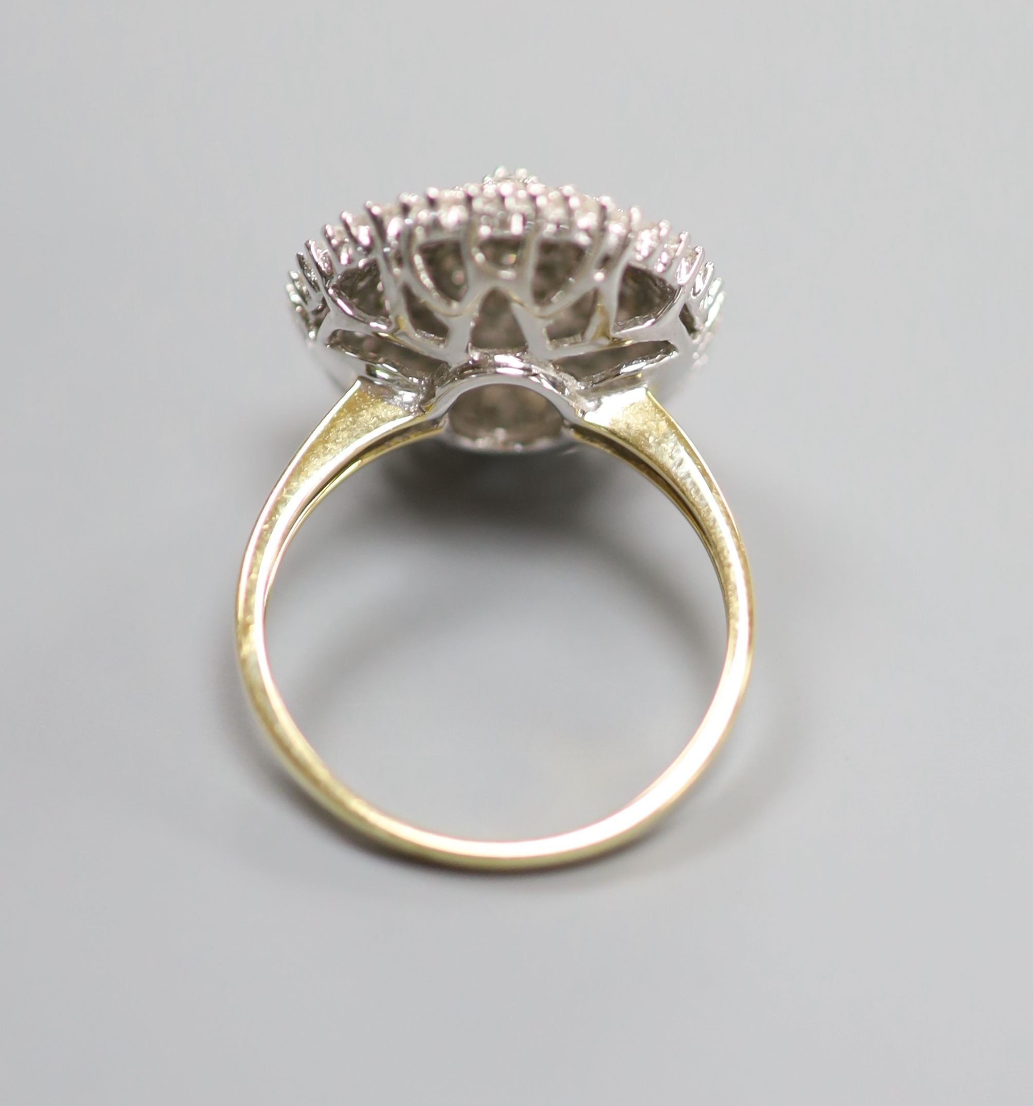 A modern 18kt and pave set diamond oval cluster dress ring, size P, gross weight 6.8 grams.